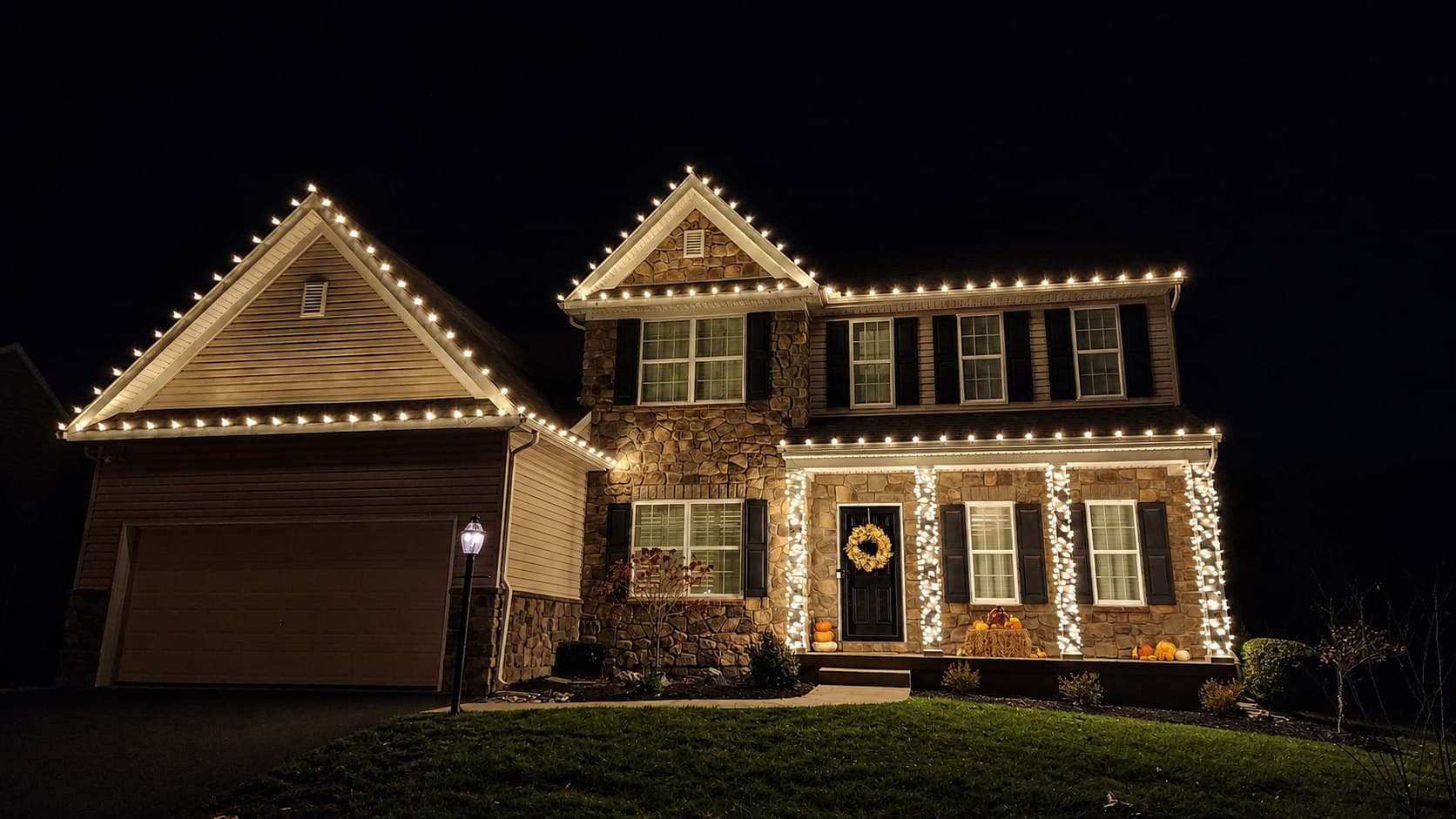 Warm-white tree, roofline, porch, and landscape lighting on a colonial home in Lititz, Pennsylvania