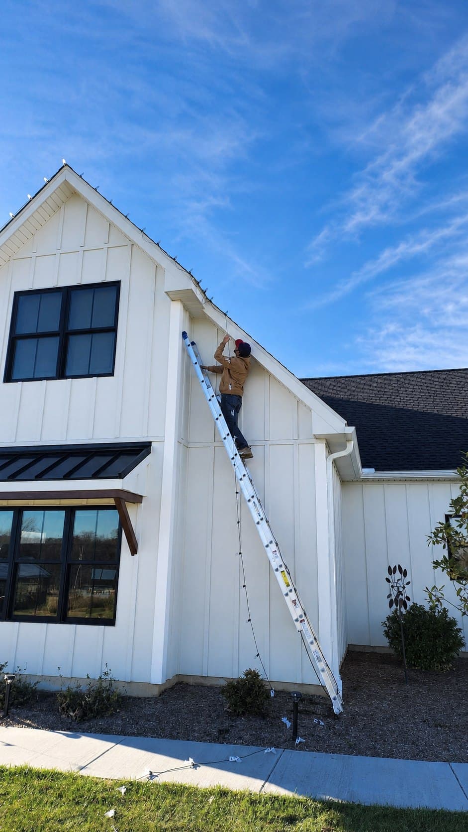 Penn Holiday Lights installer fitting C9 lights to a tall gable in New Providence, Pennsylvania